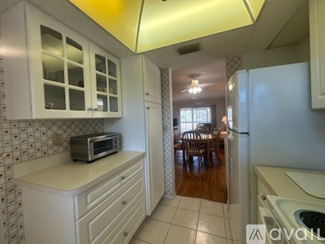 A kitchen with white cabinets and a microwave on the counter.