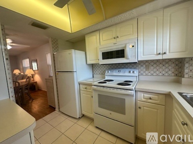 A kitchen with white appliances and cabinets.