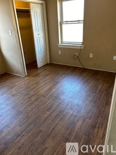 A room with wooden floors and a window.