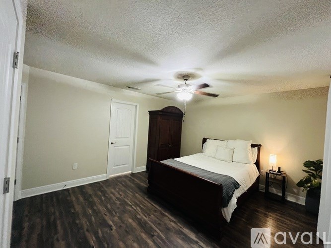 A bedroom with a bed, nightstand, and a ceiling fan.