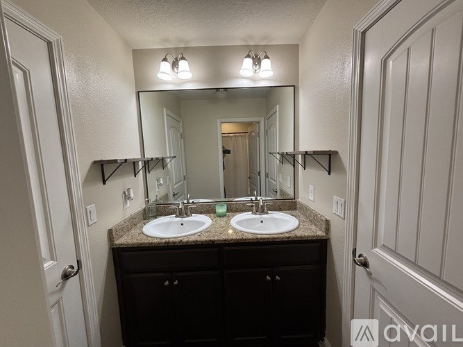 A bathroom with a vanity and a mirror above it.
