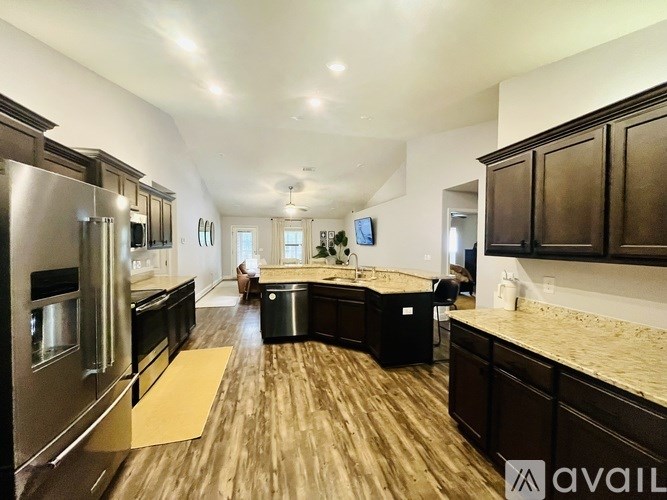 A modern kitchen with dark wood cabinets and stainless steel appliances.
