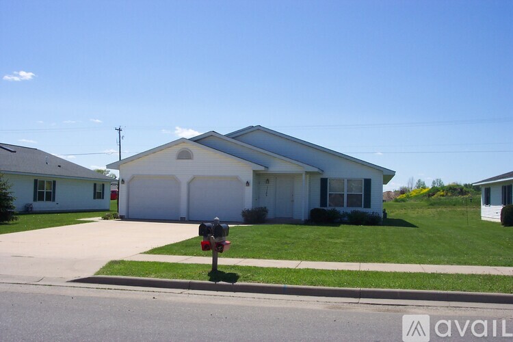A house with a garage and a mailbox in front.
