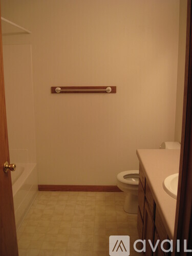 A bathroom with a toilet, sink, and a towel bar.