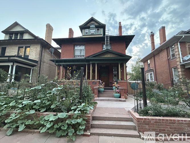 A Victorian style house with a front porch and a garden.