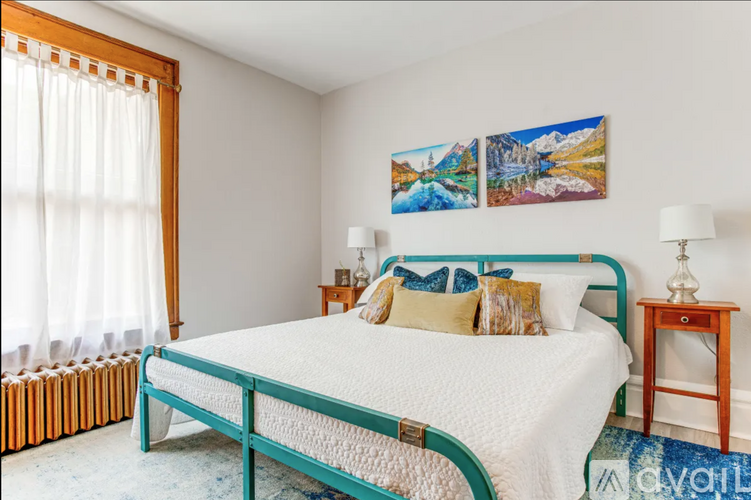 A bedroom with a blue bed frame and a white bedspread.