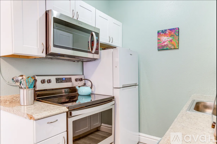 A kitchen with white cabinets and a stove top oven.