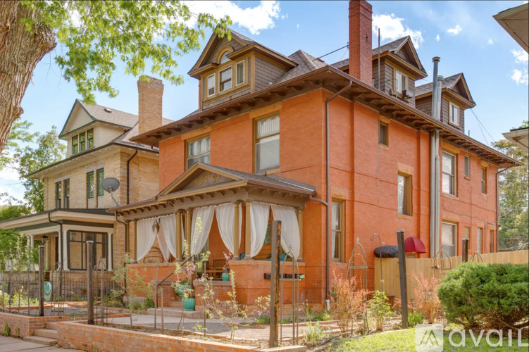 A large, two-story house with a red brick exterior and a large front porch.