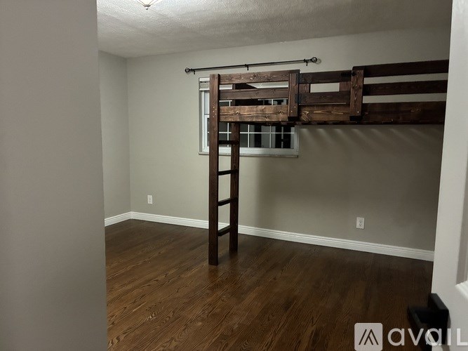 A room with a wooden floor and a bunk bed.