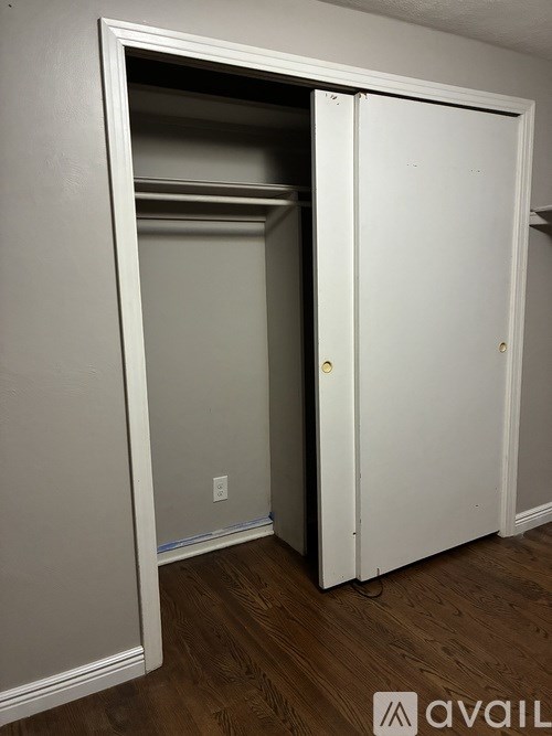 A white door is open to a small, empty room.