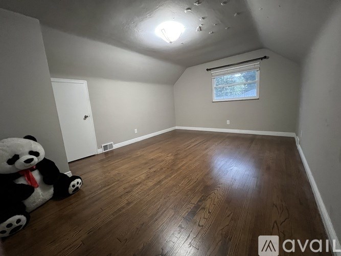 A room with wooden flooring and a window with blinds.