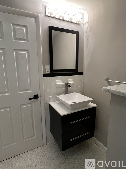 A bathroom with a white sink and a mirror above it.