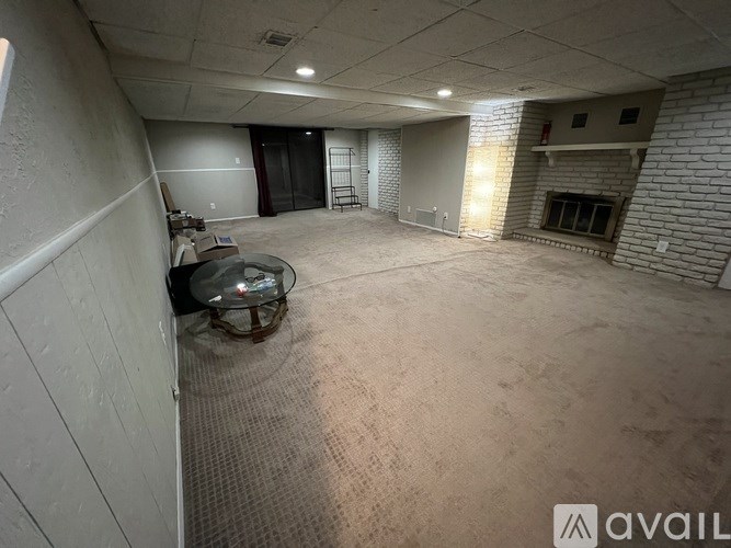 A spacious room with a fireplace and a glass table.