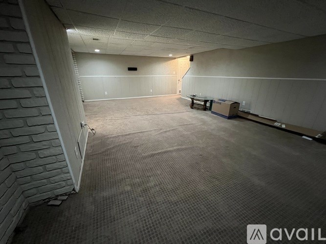 A room with a carpeted floor and a brick wall.