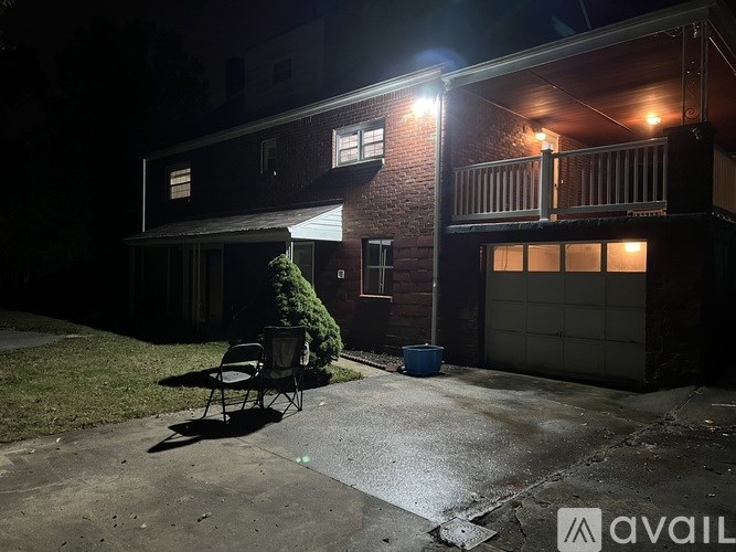 A backyard with a lawn chair and a small tree.