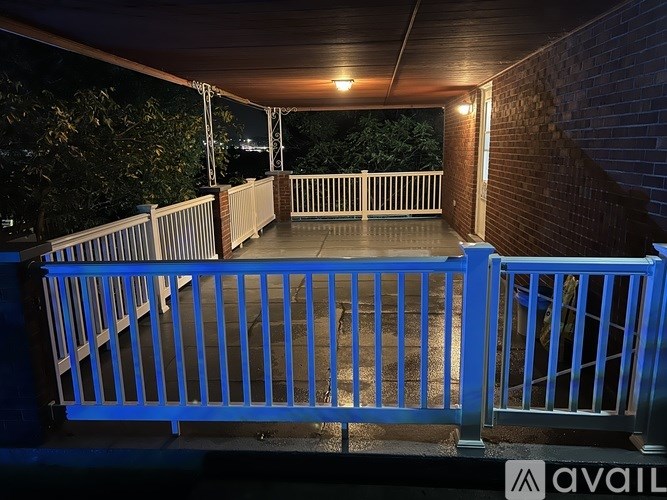A small shed sits in a grassy area next to a house.