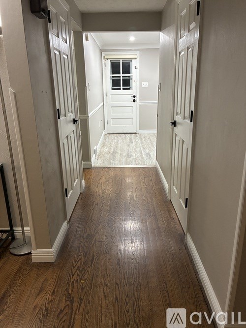 A hallway with wood floors and white doors.