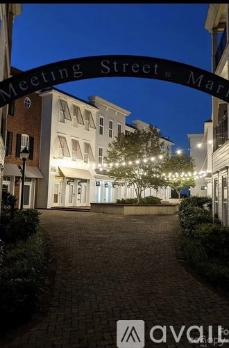 A street view of Meeting Street with a signboard and buildings on either side.