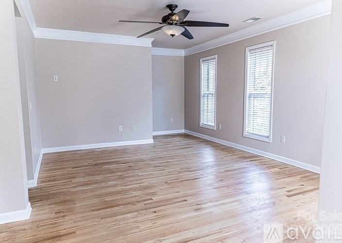 A room with a ceiling fan and wooden flooring.