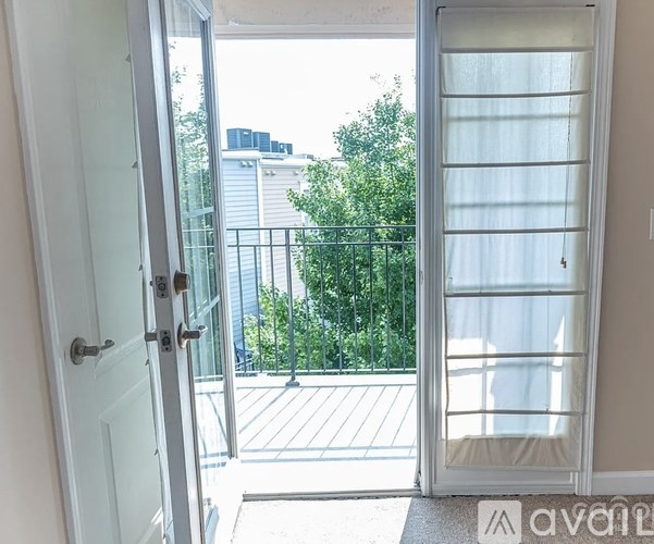 A balcony with a railing and trees in the background.