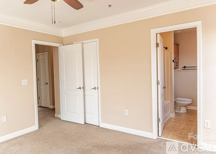 A room with a ceiling fan and two doors.