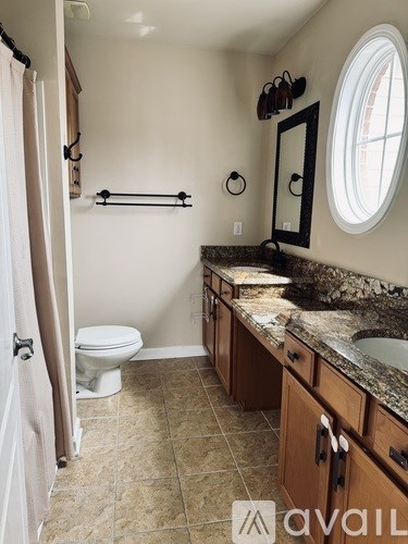 A bathroom with a toilet, sink, and mirror.