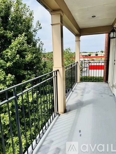 A balcony with a metal railing and a white floor.