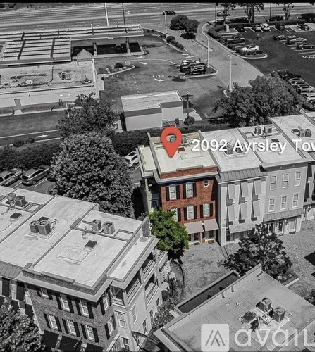 An aerial view of a city with a red marker pointing to a building with the text "2092 Ayrshire Tow".