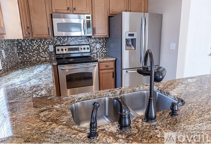A kitchen with granite countertops and stainless steel appliances.