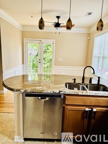 A kitchen with granite countertops and a stainless steel dishwasher.