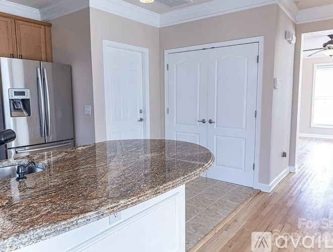 A kitchen with granite countertops and white cabinets.