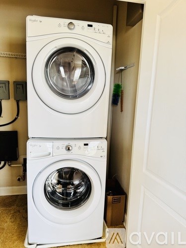 Two white front loading washing machines in a small laundry room.