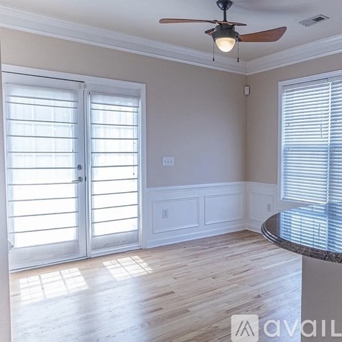 A room with a ceiling fan and a table with a marble top.
