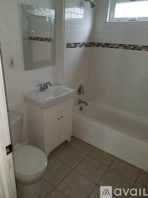 A white bathroom with a toilet, sink, and bathtub.