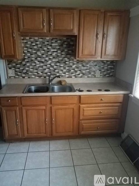 A kitchen with wooden cabinets and a checkered backsplash.