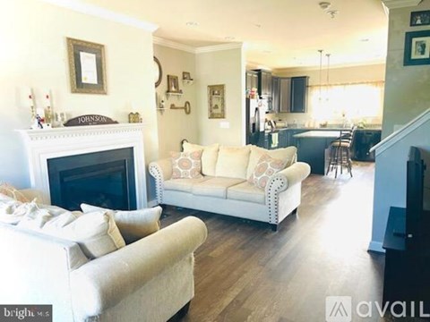 A living room with a white couch and a fireplace.
