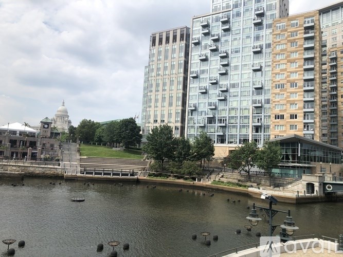 A view of a river with a boat docked at the side and a building with the word "Avolon" on it.