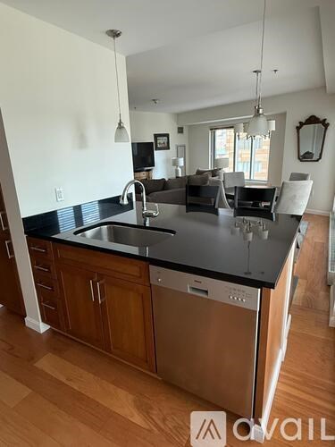 A kitchen with wooden cabinets and a black countertop.