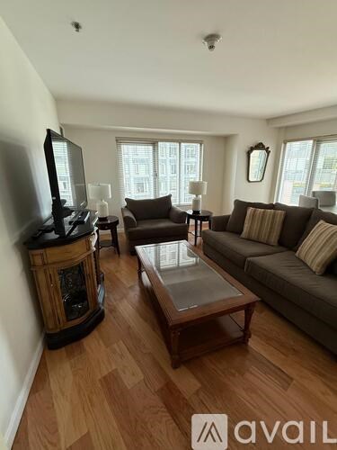 A living room with a brown couch, a wooden coffee table, and a television.