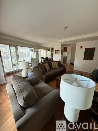 A living room with a grey couch and a white lamp.
