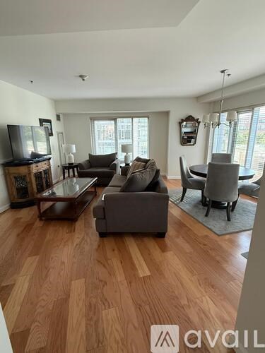 A living room with a wooden floor and furniture.