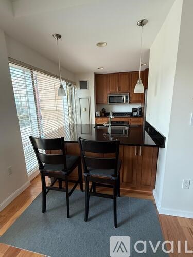 A kitchen with a table and chairs in front of a window.