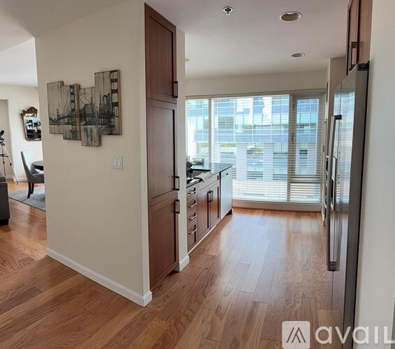 A kitchen with wooden floors and a large window.