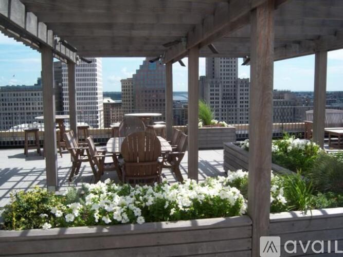 A wooden patio with chairs and tables overlooking a city skyline.