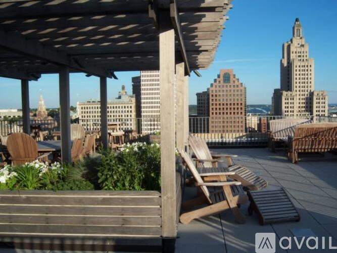 A patio with chairs and a view of a city skyline.