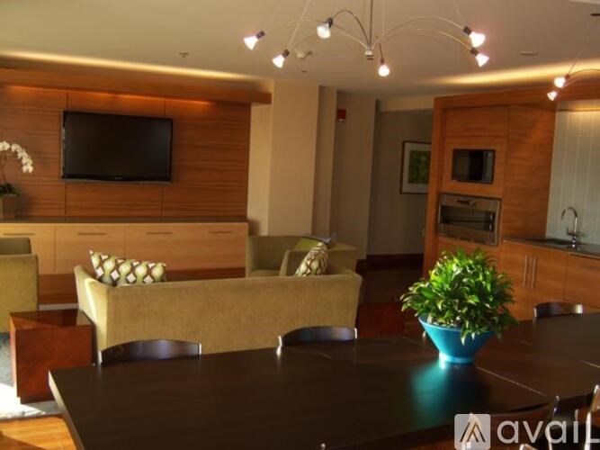 A living room with a couch, a television, and a potted plant.