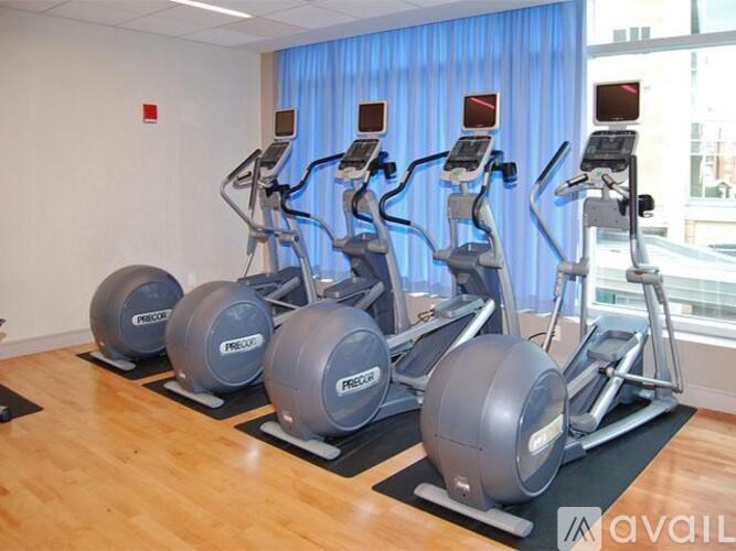 A gym with a row of stationary bikes and a row of exercise balls.