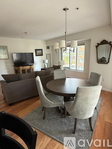 A living room with a grey couch, a wooden table and a television.