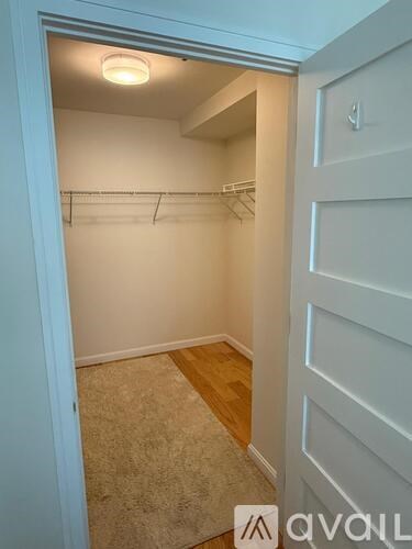 A small, empty room with a carpeted floor and a door on the right.