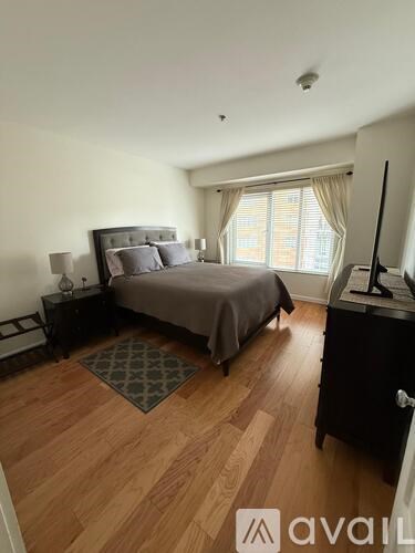 A bedroom with a bed, nightstand, and television.